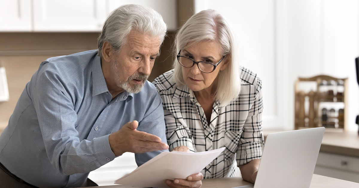 A worried couple examines investing statements after chasing stock market hype.