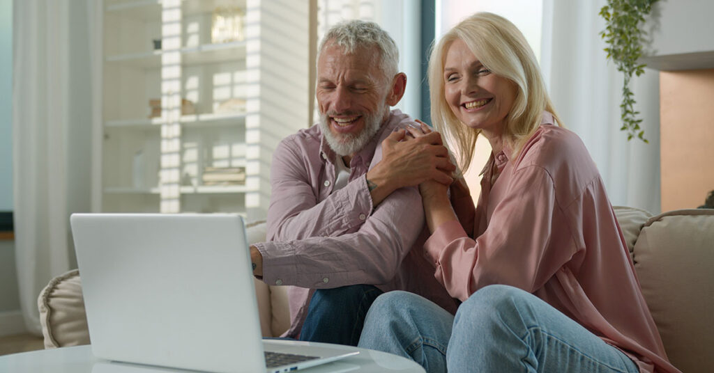 Retired couple smiling at home while reviewing their tax-smart plan—confidence made possible by a Family Office Director at Financial Gravity.